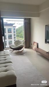 a living room with a couch and a large window at Tinghaitang in Recao