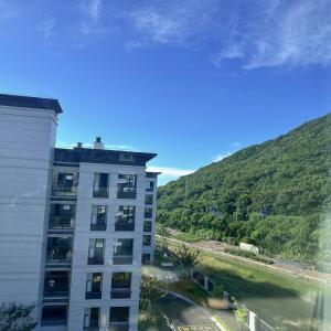 a building next to a river next to a mountain at Tinghaitang in Recao