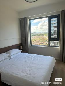 a bedroom with a white bed and a large window at Tinghaitang in Recao
