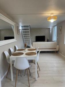 ein Esszimmer mit einem weißen Tisch und Stühlen in der Unterkunft Perfect cocoon for a romantic stay in La Celle-sous-Gouzon