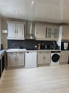 eine Küche mit weißen Schränken und weißen Geräten in der Unterkunft Perfect cocoon for a romantic stay in La Celle-sous-Gouzon