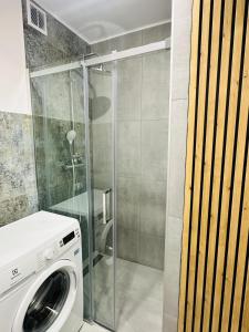 een wasmachine in een badkamer met een douche bij Kwatera na Zakładowej in Starachowice