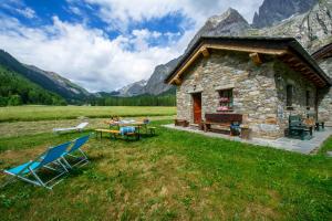 una cabina in montagna con tavolo e sedie di Chalet Maison Felix a Pra Neiron