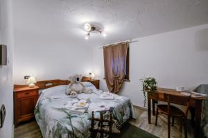 una camera da letto con un orsacchiotto seduto su un letto di Chalet Maison Felix a Pra Neiron