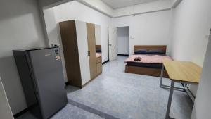 Camera con letto, scrivania e frigorifero. di หลังมอ บิวตี้ อพาร์ตเมนต์ เปลี่ยนชื่อเป็นหลังมอ อพาร์ทเมนท์สามสาว ห้องพักจะอยู่ในทาวเฮ้า2ชั้น เเจ้งเปลี่ยนที่พัก a Ban Hua Khwai