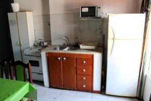 een keuken met een wastafel en een witte koelkast bij Clau Propiedades in San Antonio Oeste +4 foto's