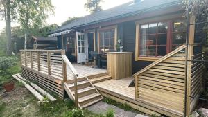 une maison avec une terrasse en bois et une table dans l'établissement Tallbo24, 