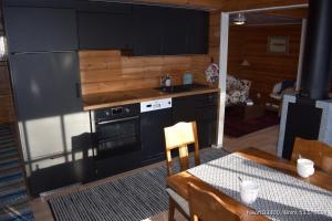 a kitchen with black cabinets and a table and a table and chair at Tallbo24 in Klofsan
