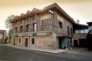 a wooden building with a balcony on the side of it at Hotel La Alfonsina in Santibáñez de Villacarriedo