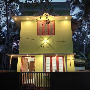 ein kleines Haus mit roten Rollläden drauf in der Unterkunft Sandora Home Stay in Varkala