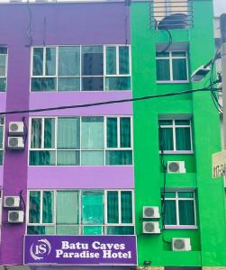 een kleurrijk gebouw met een bord ervoor bij Batu Caves Paradise Hotel in Batu-grotten