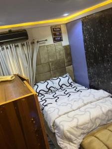 una habitación con una cama y un tocador. en TOPS LOUNGE and suites, en Agbelekale