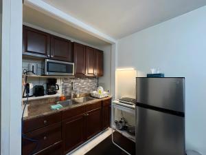 a kitchen with wooden cabinets and a stainless steel refrigerator at Chapman H in Toronto