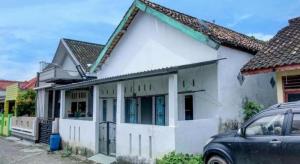 a white house with a car parked in front of it at Hotel O Penginapan Indola Near Masjid Al Muhtadin in Muaradua