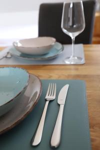 een tafel met twee vorken, borden en een glas bij Ferienwohnung Documenta Urbana in Kassel