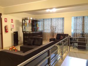 sala de estar con 2 sofás y balcón en Hostal Gold Star en Tacna