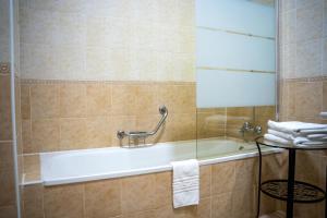 uma casa de banho com uma banheira e um toalheiro. em La Palmosa em Alcalá de los Gazules mais 30 fotografias