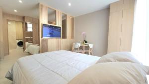 a bedroom with a large white bed and a television at Studio du Soleil in Le Val +27 photos