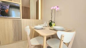 a dining room table with two chairs and a table with a tv at Studio du Soleil in Le Val