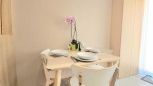 a table with plates and a vase with a flower on it at Studio du Soleil in Le Val