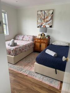 a bedroom with two beds and a nightstand and a bed sidx sidx sidx sidx at Wallawa on Hilltop in Ellesmere