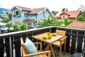 een houten tafel en stoelen op een balkon bij Strömbergs Merle in Oberstaufen