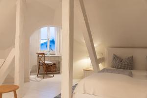 een slaapkamer met een bed, een stoel en een raam bij Strömbergs Merle in Oberstaufen