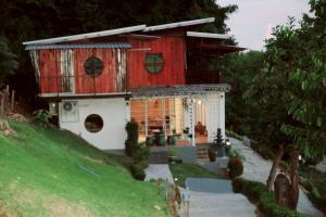 een rood-wit huis op een heuvel bij Grandpa's House in Ko Klang