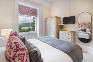een slaapkamer met een groot bed en een spiegel bij 2 Bed in Soulby oc-a28927 in Pooley Bridge