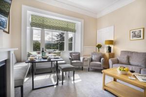 een woonkamer met een tafel, stoelen en een bank bij 2 Bed in Soulby oc-d28926 in Pooley Bridge +3 foto's