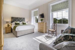 een slaapkamer met een bed, een bank en ramen bij 2 Bed in Soulby oc-d28926 in Pooley Bridge