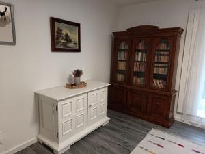 a room with a book shelf and a white cabinet at Tornác Vendégház in Diszel