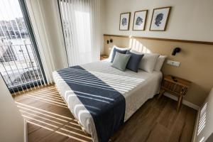 een slaapkamer met een groot bed en een groot raam bij Apartamentos PRAIA DO CANSORRO in Camariñas