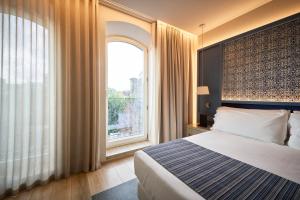 波尔图Catalonia Porto的一间卧室，里面有一张床和一扇大窗户。 更多46张照片