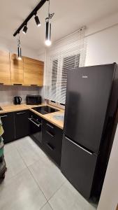 een keuken met een grote zwarte koelkast. bij Kwatera na Zakładowej in Starachowice
