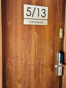 een bord op een houten deur met het nummer bij Kwatera na Zakładowej in Starachowice