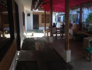 eine offene Tür eines Hauses mit einer Person, die an einem Tisch sitzt in der Unterkunft Lola's Lodge in Boracay