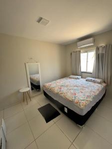 Schlafzimmer mit einem Bett und einem Spiegel in der Unterkunft Casa com piscina privativa em paracuru in Paracuru