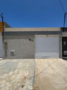 eine Garage mit einer weißen Garagentür auf einem Gebäude in der Unterkunft Casa com piscina privativa em paracuru in Paracuru + 4 Fotos