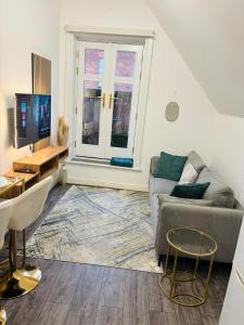 a living room with a couch and a tv at The Luxe Haven Penthouse - Sleeps 4 Apartment Nottingham City Centre in Nottingham
