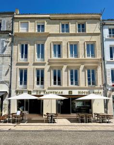 een gebouw met tafels en parasols ervoor bij Hôtel Le Yachtman, The Originals Collection in La Rochelle