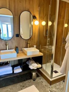 een badkamer met een douche, een wastafel en een spiegel bij Hôtel Le Yachtman, The Originals Collection in La Rochelle