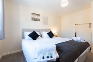 una camera da letto con un letto grande con lenzuola bianche di Greatdown RnR Stays a Greenford Altre 3 foto