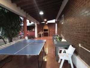 a ping pong table in a room with a brick wall at El Guembe Hostel House in Puerto Iguazú