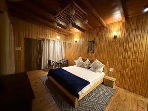 a bedroom with a bed in a wooden wall at The Hilltop Hideaway in Mukteshwar