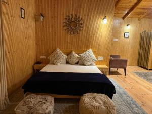 a bedroom with a bed and a chair in a room at The Hilltop Hideaway in Mukteshwar