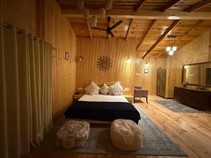 a bedroom with a bed in a room with wooden walls at The Hilltop Hideaway in Mukteshwar