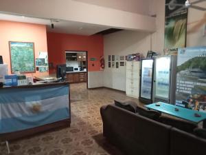 a restaurant with a counter and chairs in a room at El Guembe Hostel House in Puerto Iguazú