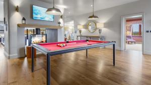 a red pool table in a living room with a fireplace at Badgerwood in Winchcombe