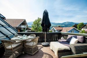 een terras met een tafel, stoelen en een parasol bij Strömbergs Gunnar in Oberstaufen